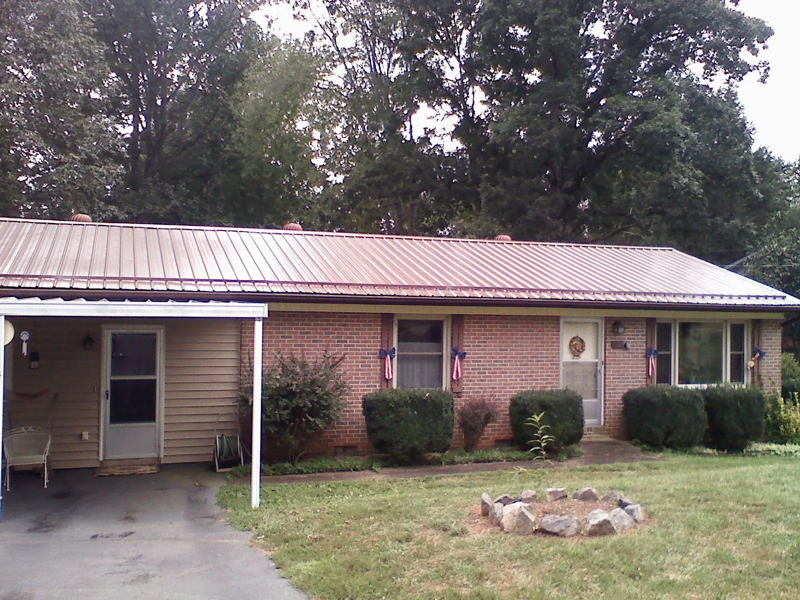 Bronze metal roof and carport on a brick ranch home — Roof Repair work by our crew in Crossville